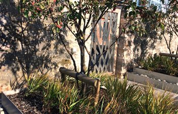 Stainless steel entrance gate for a contemporary walled garden.