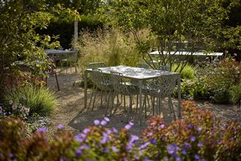 Hestia Garden at The Plough Shiplake in Oxfordshire; view of dining tables amongst the planting beds. Photograph Alister Thorpe.