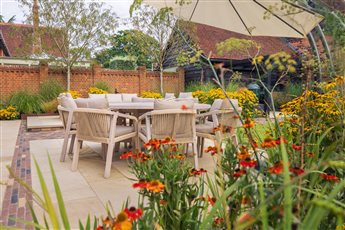 A sumptuous dining area in a restored stableyard garden.