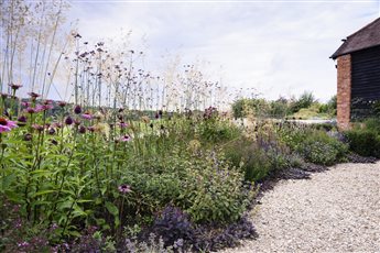 An extensive, sunken porcelain and clay paver dining and entertaining terrace close to the house, includes a barbeque and hot tub area. A black basalt path leads beneath an oak pergola to the games room, wildflower planting and a woodland garden.