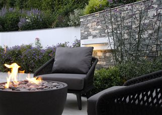  a modern, textural courtyard in Sevenoaks using a muted palette of wood, grey porcelain and nordic tier cladding. This semi enclosed space creates a wonderful connection to the newly refurbished home which leads upto the lawn and summerhouse