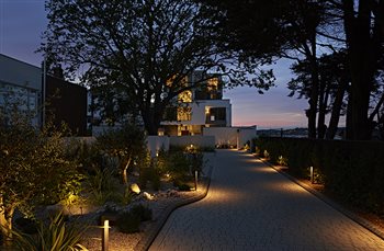 The coastal position of the site has been reflected by the use of river-worn glacial boulders and pebble-mulched planting beds. Strategically positioned LED lighting brings drama to the exterior after dark.