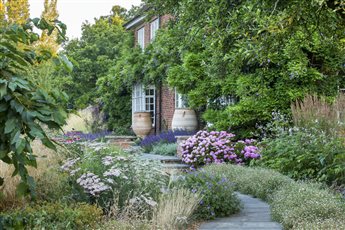 Mixed sessional planting lines the path to the house in this  large country garden - voted the Nations Favourite Garden in by the NGS and English Garden Magazine 