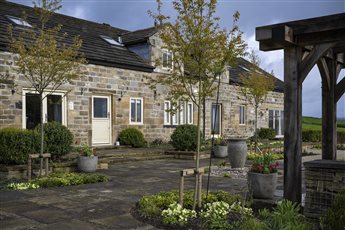 Rural garden design for a Yorkshire farmhouse on Ilkley Moor incorporating a stone Firepit circle, large bespoke oak pergola and Yorkstone paving. 
