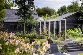 An extensive, sunken porcelain and clay paver dining and entertaining terrace close to the house, includes a barbeque and hot tub area. A black basalt path leads beneath an oak pergola to the games room, wildflower planting and a woodland garden.