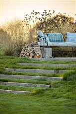 Cotswolds barn conversion - sleeper turf steps lead up to an informal lounging terrace / viewpoint across the garden.