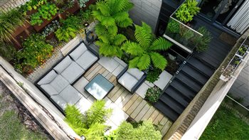 This North Facing London courtyard was paved with white porcelain and paving planks. Complete with porcelain cladding and steel walls the vertical garden also added additional interest