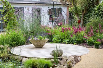 The new design is based on swirls and curves. A large spiral of porous resin bound aggregate flooring will sweep round to the back left corner of the garden, where a corner summerhouse will be placed. 