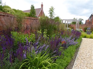 Glorious mixed planting and box lined path leading to breakfast seating area