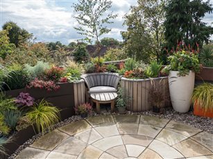 This roof garden design features a large sandstone circle in the centre of the space, with a step installed directly outside the patio door to aid transition from inside to out. 
