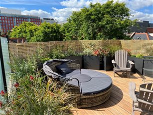 Roof garden with timber deck, slatted trellis and lounge seating