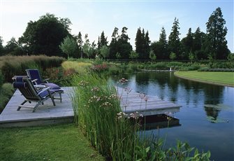 The deck projects out over the pond in this contemporary country garden on the West Sussex/Hampshire border 