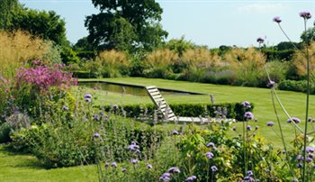 Herbaceous borders and reflective pool, garden in Devon.