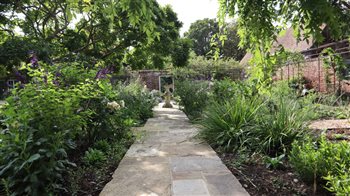 In this Georgian walled garden I created a classic quartered arrangement of reclaimed Yorkstone paths with exuberant mixed planting of roses and herbaceous perennials and an elegant metal pergola around the edges.