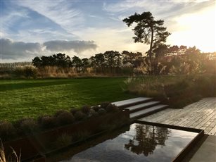 Low winter sunshine warms the grasses and casts spellbinding reflections in this contemporary country garden in Kent