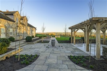 Garden design for a rural Yorkshire farmhouse on Ilkley Moor, incorporating a bubbling urn waterfeature, large bespoke oak pergola for entertaining and stone Firepit circle. 