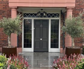 Formal front of house with bespoke planters and specimen olive trees.