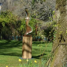 Bronze sculpture 'Bone Form II' in a spring garden. This work is approximately 130cm tall and can be placed on a plinth of various materials. Each casting is hand made to order, it could take 12-14 weeks to produce if not currently available.