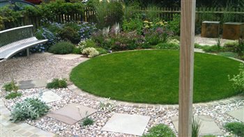 The same garden as preceding image - the circular lawn and sitting area makes it inviting to use.