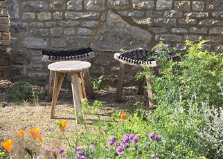 sunny sitting spot against stone wall in gravel garden