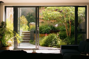 Japanese style courtyard garden. Balanced asymmetry. Curved wooden deck. abundant planting.
