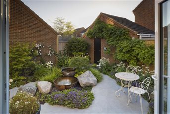 Set on an awkward triangular plot we have made a courtyard oasis. The copper water feature and boulders add a grounding element to the space whilst lush, textural planting  flows around the garden.