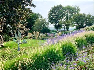 Sweeps of late summer grasses and perennials unite this downland garden to its surrounding landscape - winner of the SGD Medium Residential Garden Award 2018