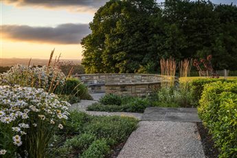 Farmhouse on Ilkley moor.  Contemporary country garden.  Large bespoke oak pergola, reclaimed yorkstone paved courtyard with waterfeature.  Stone circle firepit.