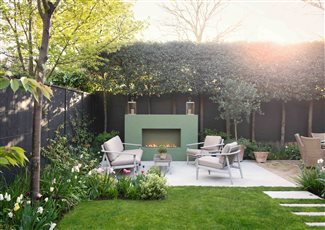 Joanna Archer Garden Design London garden with fireplace and pleached trees.