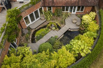 Sunshades and Decking transformed this garden in Wendover by removing an old deck and redesigning the space into a pond garden complete with a Composite Prime HD Deck Dual Antique walkway and seating area.