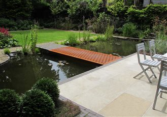 Jesmond Canal Garden with flying carpet corten bridge and sawn sandstone patio. Newcastle Upon Tyne.