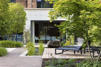 The boulder balances almost precariously over the pond with water coming up through the middle and over the edge into the pond. From the house you see the beautiful boulder and all its texture. The juxtaposition of smooth and rough is compelling.