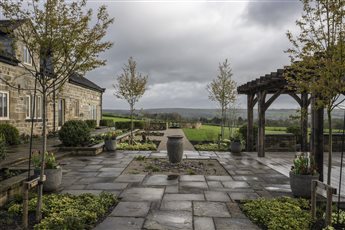 Farmhouse on Ilkley moor.  Contemporary country garden.  Large bespoke oak pergola, reclaimed yorkstone paved courtyard with waterfeature.  Stone circle firepit.