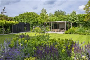 This large garden in Cobham was designed to provide lots of interest to the clients, a drum room, arbour, outdoor dining and cooking area, water feature and a large lawn