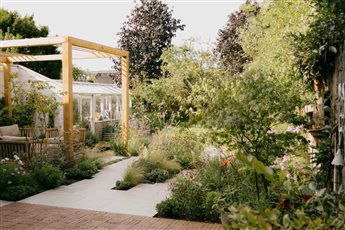 Plant focused family garden with pergola, clay pavers and limestone paving.