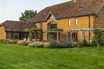 Cotswolds barn conversion - soft planting wraps around the pergola terrace.