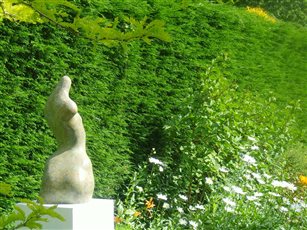 Sculpture for the garden. 'Eve IV' bronze limited edition sculpture shown in garden. This work is about 70cm tall.