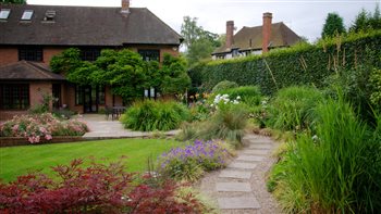 Curved path leading to a sunny sitting area.