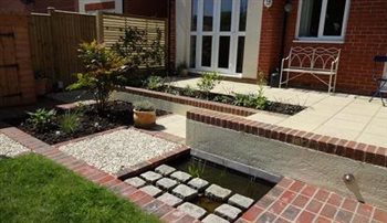 Small courtyard wildlife garden on difficult levels with pond in a new build garden.