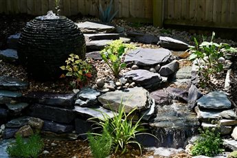 This is an example of a pondless waterfall. A pondless waterfall allows clients to have the sight and sounds of water with the least amount of maintenance. A choice for small and large gardens alike due to them being bespoke.