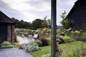 An extensive, sunken porcelain and clay paver dining and entertaining terrace close to the house, includes a barbeque and hot tub area. A black basalt path leads beneath an oak pergola to the games room, wildflower planting and a woodland garden.